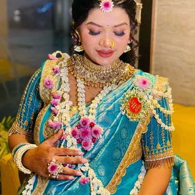 A glowing mom-to-be celebrating her dohale jevan. She is wearing a custom set I created using white jasmine buds and pink flowers, complete with a matching floral ring and bajuband.