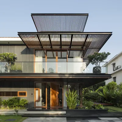 The renovated facade of Villa re:FORM, where we introduced a system of linear pergolas and a cantilevered balcony. The interplay of horizontal and vertical lines frames views and creates a dynamic play of light and shadow.
