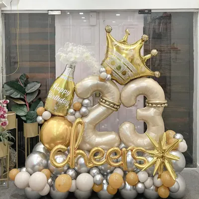 Celebrate turning 23 in style with this luxe arrangement. Featuring a popping champagne bottle, a golden crown, and "cheers" script, this display in a sophisticated silver and gold palette is designed to feel like a true royal celebration.