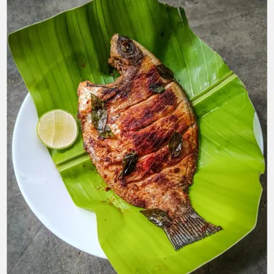 A whole Tawa Grilled Karimeen (Pearlspot) served on a banana leaf. I source this wild-caught fish from Kerala and cook it with a simple salt and chilli rub in coconut oil to let its delicate, natural flavour shine.