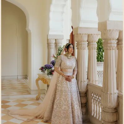 A bridal portrait in the serene, sunlit corridors of Rambagh Palace. The historic architecture provides a timeless frame for the bride's modern elegance.
