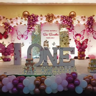 This was an unforgettable first birthday celebration with an enchanting butterfly theme. I designed a full stage setup featuring large 'ONE' marquee letters, intricate balloon arrangements in pinks and whites, and beautiful butterfly details throughout. It's all about creating a grand and memorable first milestone.