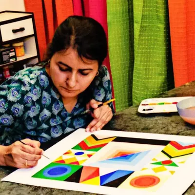 I'm so excited to be restarting my adult art classes! Here, a student is engrossed in a geometric painting, a style that requires precision and a good eye for color.