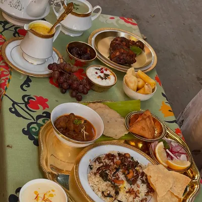 Our Eid table tells a tale from Arab sails to Malabar shores. This grand spread features fragrant biryani, rich mutton curry, grilled chicken, fresh fruits, and sweet payasam, a true feast for the senses.