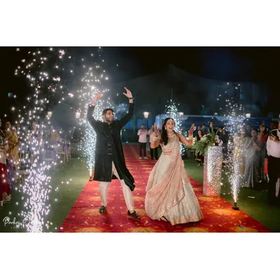 A grand entrance for a magical Sangeet night. Zaee and Kartik make their way down a red carpet lined with sparklers, a perfect start to an evening of celebration.