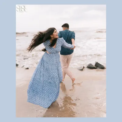 A playful moment on a Goa beach, where her hair dances in the wind as he leads her by the hand. This is the kind of carefree energy that makes beach pre-wedding shoots so special.