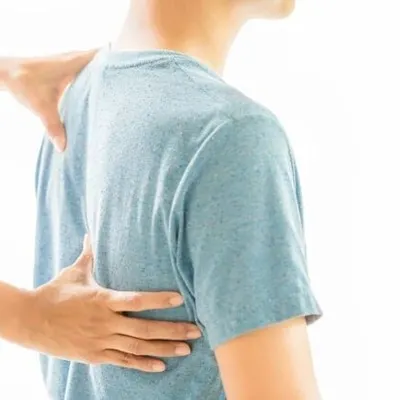 Back pain can stem from many causes, including poor posture, injury, or degenerative conditions. Here, a therapist assesses a patient's back, the first step toward creating a personalized relief plan.