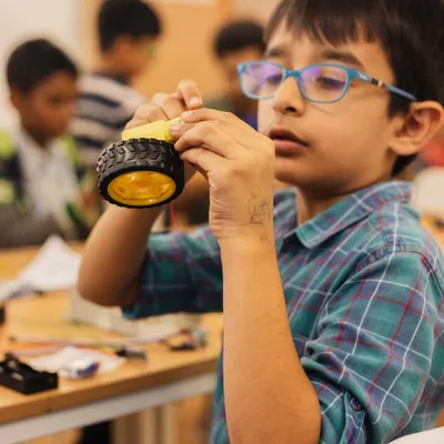 A young innovator completely focused on his robotics project. Here, children learn to build and tinker with autobots, developing logical thinking and problem-solving skills.