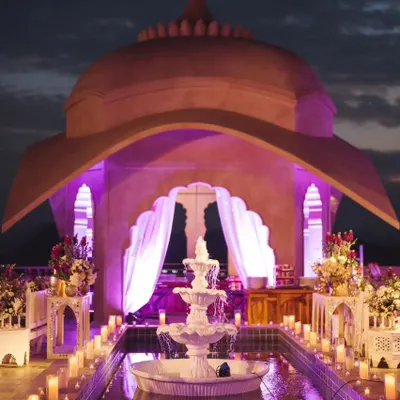 The stunning rooftop setup for a Sufi night at the Fairmont Jaipur. The combination of the architectural dome, purple uplighting, and candlelit water feature created a truly magical and romantic ambiance.