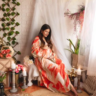 A beautifully serene solo portrait in our boho-themed studio corner. The space is filled with candles, pampas grass, and soft fabrics, creating a warm and peaceful atmosphere for the mom-to-be.