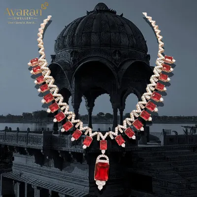 A fiery and dramatic statement necklace. This piece features brilliant red stones set in a zigzag pattern of sparkling zircons, designed to capture attention and make a bold style statement.