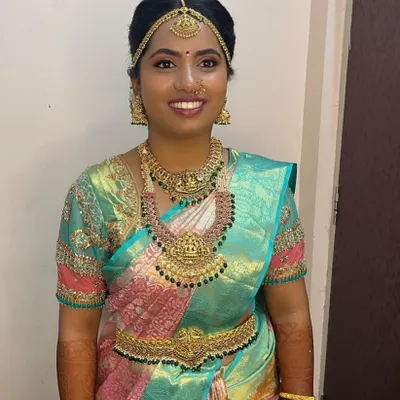 A happy client looking radiant on her wedding day in a complete South Indian temple jewellery set. The set includes a choker, Lakshmi haar, and matching vaddanam.