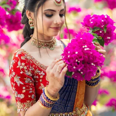 A beautiful engagement look. The bride is surrounded by bright pink bougainvillea, and her makeup is kept fresh and romantic to match.