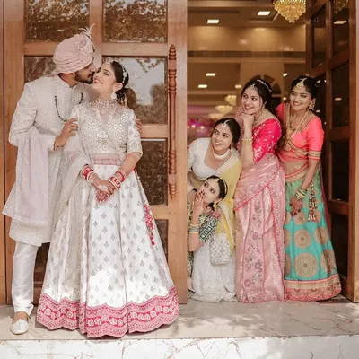After the fun shots, we love to capture the romance. Here, the groom shares a sweet kiss with his bride while the bridesmaids look on, creating a beautifully composed group portrait that is both sweet and elegant.