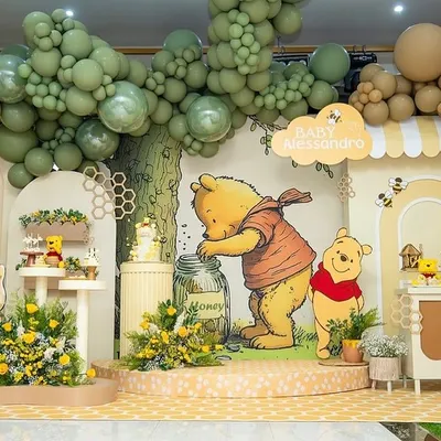 A complete Winnie the Pooh themed baby shower stage, featuring a honey pot cake stand, character cutouts, and a balloon tree. The entire setup is designed to look like a scene from the Hundred Acre Wood.