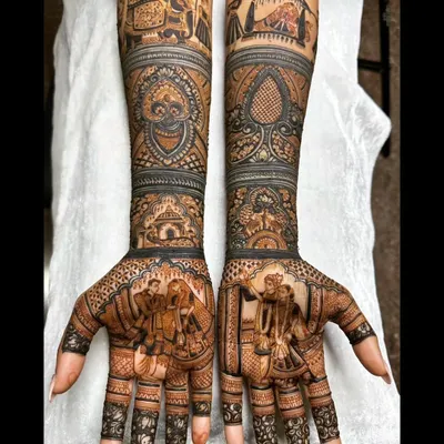 For this South Indian bride, we depicted a classic wedding procession on the forearms, complete with elephants and a doli, while the palms feature a portrait of the couple during the ceremony.