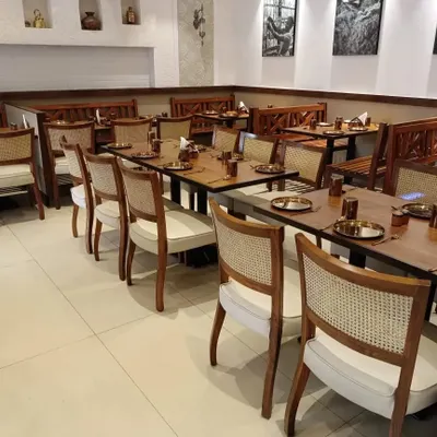A wide view of the dining area at 'The Big Fish & Co.' restaurant in Dadar. I supplied all the furniture, including the cane-back chairs, solid wood tables, and benches, to create a cohesive and inviting atmosphere for diners.