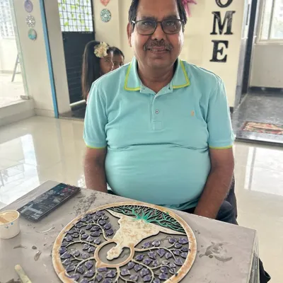 A happy participant with his finished 'Tree of Life' texture art piece.