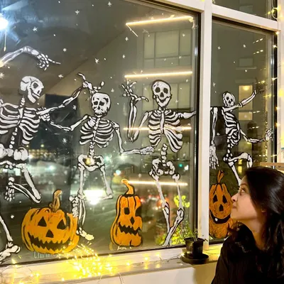 Getting into the Halloween spirit with a full-window painting of dancing skeletons and jack-o'-lanterns at our New Jersey studio.