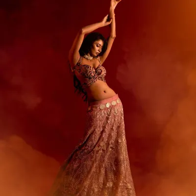 This shot is pure art and movement. I used smoke and warm, dramatic lighting to create an ethereal atmosphere, capturing the model in a graceful dance-like pose that highlights the flow of her lehenga.