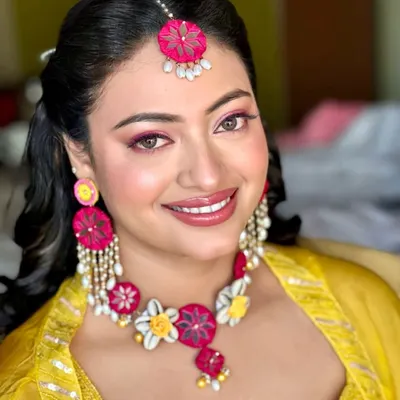 A soft pink finish for a Haldi ceremony. I paired a bright pink eyeshadow and lip with the bride's yellow outfit and floral jewelry for a fun, colorful, and festive look.