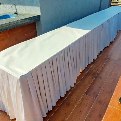 A clean and simple buffet table setup with a white pleated skirt. This is a basic and versatile catering arrangement that I provide for all types of events, whether on a terrace, in a garden, or indoors.