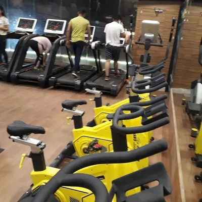 A view of our dedicated cardio area, featuring a line of stationary bikes and treadmills. We ensure our equipment is always ready for you to get a great solo workout anytime.