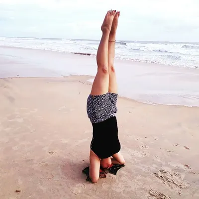 Practicing Sirsasana (Headstand) on the beach. The sound of the waves and the sand beneath provide a unique and grounding experience.
