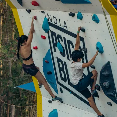 Two climbers go head to head on the Psicobloc wall. You can see the different routes set for the Psico Battle, designed to test both speed and technique.