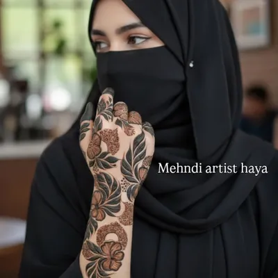 A beautiful client photo showcasing a bold Arabic floral design. The pattern flows elegantly along the side of the hand and wrist, a perfect accessory for her outfit.