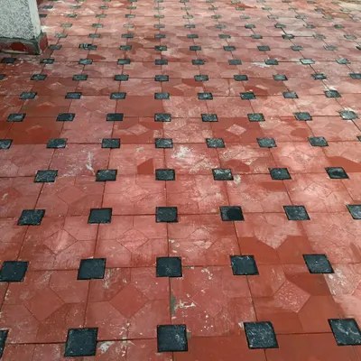 This image shows the process of laying a durable and decorative outdoor patio floor. I used a combination of terracotta and black tiles to create a classic, long-lasting pattern that can withstand the elements.