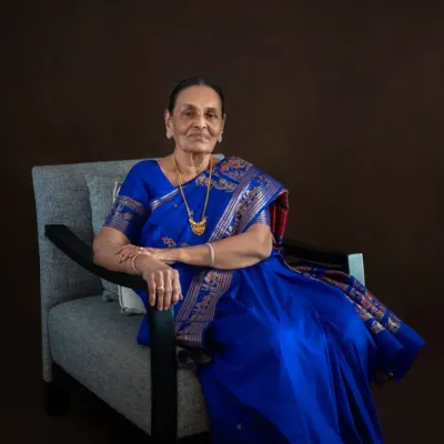 For her 90th birthday portrait session, we captured this elegant seated photo in a stunning royal blue saree. The rich color and her poised demeanor create a regal and timeless image for her family to cherish.
