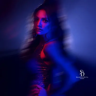An abstract portrait using motion blur and colored gels. The streaks of red and blue light create a sense of energy and movement, resulting in a dynamic and artistic image.