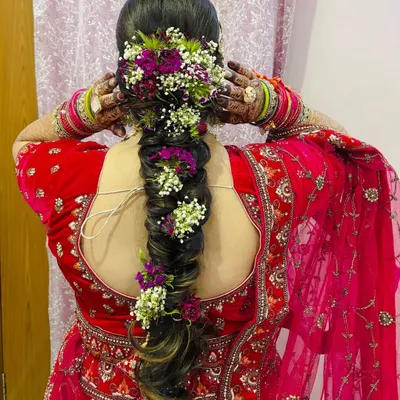 A stunning view of a thick, floral bridal braid. I used a mix of purple and white flowers to match the bride's lehenga, creating a truly unique look.