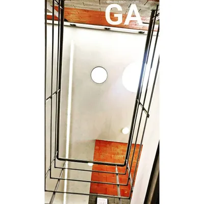 Looking up through a multi-story interior space towards a circular skylight. This design element, seen here in an industrial office, pulls natural light down through the building, illuminating the workspaces and reducing the need for artificial lighting.