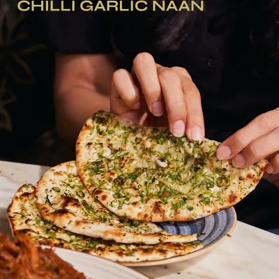 There's nothing quite like tearing into a piece of our Chilli Garlic Naan. Fresh from the tandoor and generously topped with garlic and herbs, it's the perfect partner for our slow-cooked Raan Musallam.