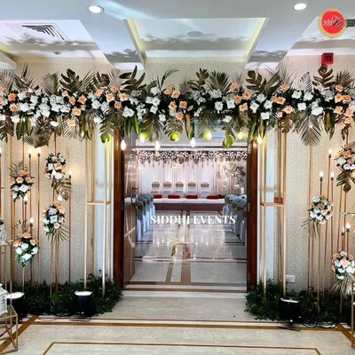 An exceptionally grand and elegant entranceway. We used tall golden frames, lush arrangements of peach and white florals, and soft lighting to create a breathtaking first impression.