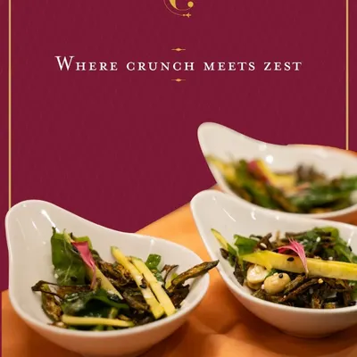 A refreshing salad of crisp-fried okra and julienned raw mango. This dish offers a delightful play of textures and a tangy zest, making it a light and vibrant starter for any occasion.