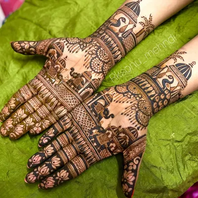 A stunning example of traditional bridal mehndi, with both hands covered in dense, intricate patterns. This design features classic motifs like elephants, peacocks, and lotuses, perfect for a grand wedding celebration.