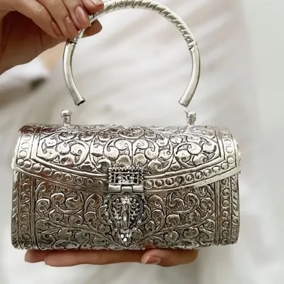 I believe accessories should be timeless works of art. This intricately carved German silver clutch is a statement of pure elegance, perfect for weddings and festive evenings. It is handcrafted to be an heirloom piece you will treasure forever.