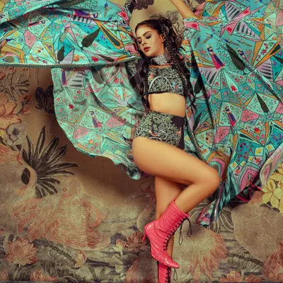 A high-energy shot from an editorial with Priyanka Chahar Choudhary. The makeup is bold and defined to match the vibrant styling and dynamic pose.
