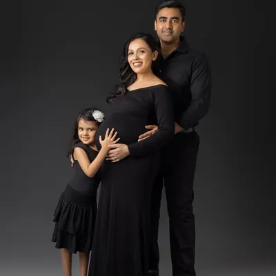 A beautiful portrait of a growing family. The older sister-to-be gives her new sibling a hug, a perfect moment of connection.
