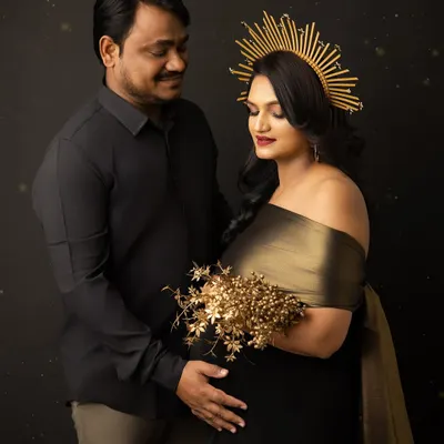 A powerful and loving portrait of an expecting couple. The golden halo and bouquet add a touch of divine glamour to this modern maternity shoot against a dark, dramatic backdrop.