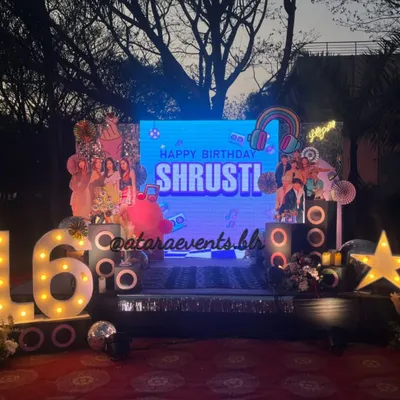 The stage is set for a K-Pop superstar! This 16th birthday bash features a large LED screen, speaker props, and '16' marquee lights, creating a concert-like atmosphere for a night of music and dancing.