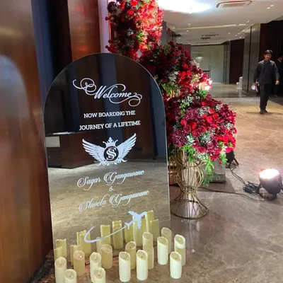 A personalized welcome sign on a mirror, with a clever "Now boarding the journey of a lifetime" message for a couple connected to aviation.