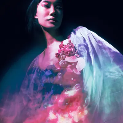 A portrait where the model is bathed in soft pink and blue light, creating a painterly, ethereal effect. The motion blur and floral costume evoke the tragic beauty of Ophelia, reimagined with a contemporary, dreamlike quality.