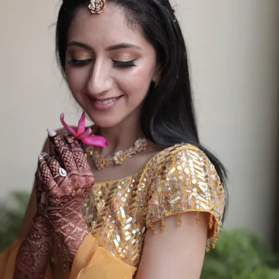 Sun-kissed perfection for a Haldi ceremony. I created this fresh and dewy look with golden shimmery eyeshadow and a soft pink lip to complement her yellow outfit. The focus is on radiant, glowing skin that looks natural and beautiful.