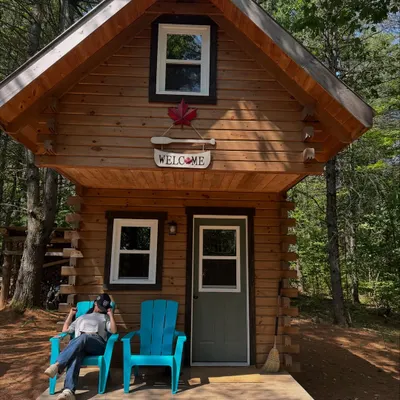 A relaxing moment at a cozy cabin. This shot captures a peaceful, rustic vibe, perfect for brands in the travel, wellness, or comfort apparel space.
