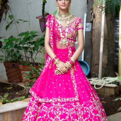 This outdoor shot of a bridal lehenga uses natural light to bring out the richness of the pink fabric and the sparkle of the embroidery. Location shooting for bridal wear helps create a beautiful and aspirational narrative.