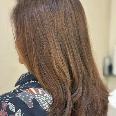 A classic layered haircut that adds movement and removes weight from medium-length hair, styled to show off the fresh, clean lines.